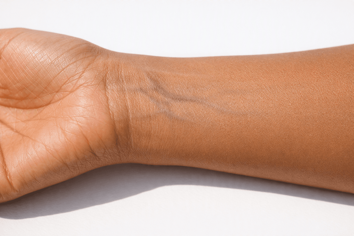 Demonstração do teste de pulso em pele morena mostrando veias para identificação de subtom